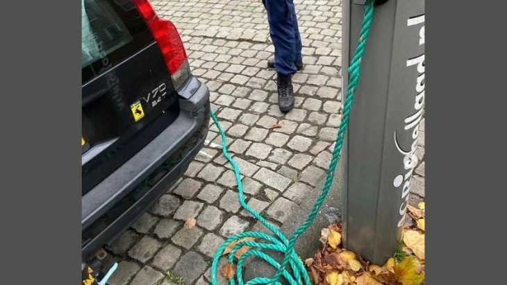 automobilist hangt touw tussen zijn 'elektrische' auto en laadpaal